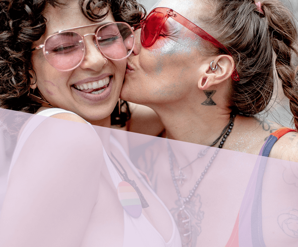 Woman Kissing a Smiling Female on the Cheek